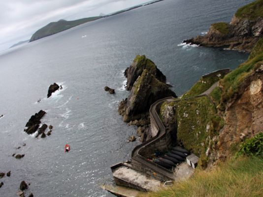 Dunquin. Landing stage to the Great Blasket Island. The name of the fisherman Tomas Keane who disappeared nearby is written on it. A few Curraghs boats, called naomhóg in this area..