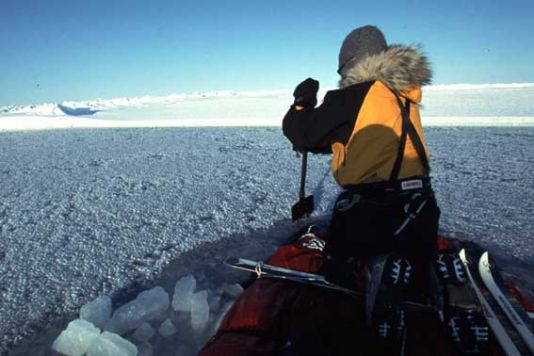 Fully loaded, that is to say in the first weeks of the expedition, the two men could then go on top together, and there still remained - in the lowest part in the middle of the sledges - approximately fifteen centimetres above the water line. In this shot, you can see Alain using the ice shovels as paddles for advancing the craft.